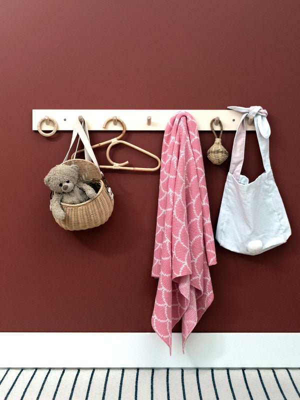 Pink Passionfruit and Lemonade baby blanket hanging from coat rack